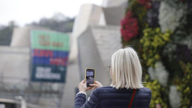 Una señora toma fotografías de Bilbao, en Bizkaia