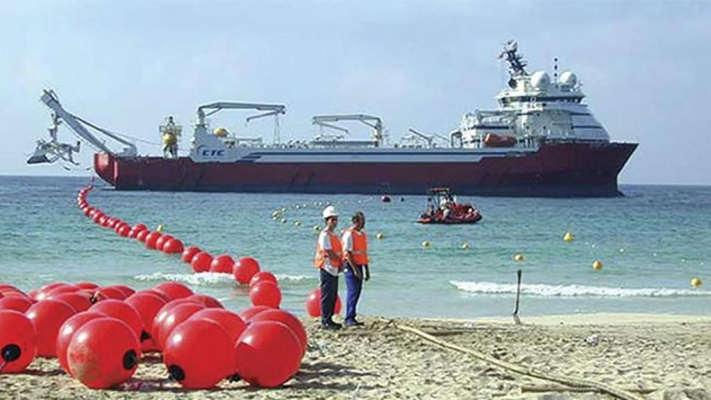 Un barco arrastra una línea con boyas indicando la ruta del cable submarino / EFE