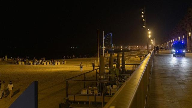 Un coche de policía vigila la playa de la Barceloneta (Barcelona)