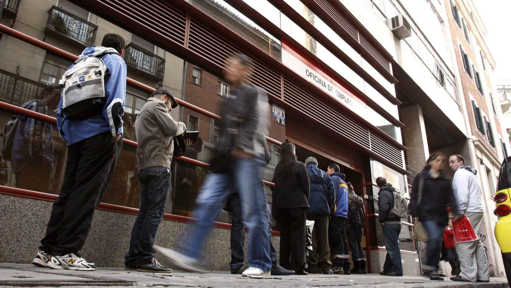 Personas entrando y saliendo de una oficina de empleo / EFE