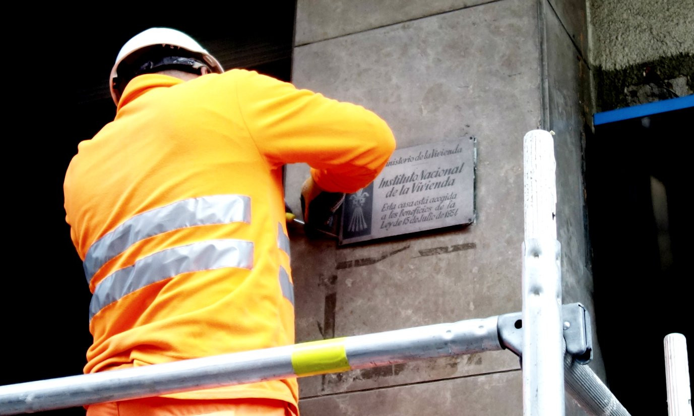 Un operario retira de forma oficial la primera placa franquista de Barcelona / DGM