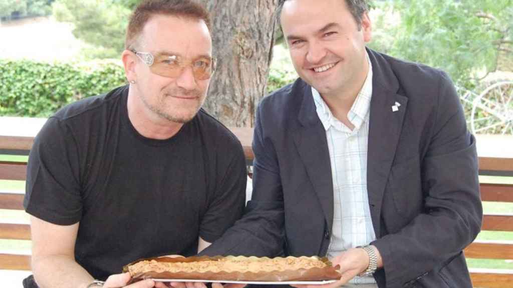 Bernat Graupera entregando una coca de Llavaneres al cantante de U2, Bono / Raquel Begines, Ajuntament de Llavaneres