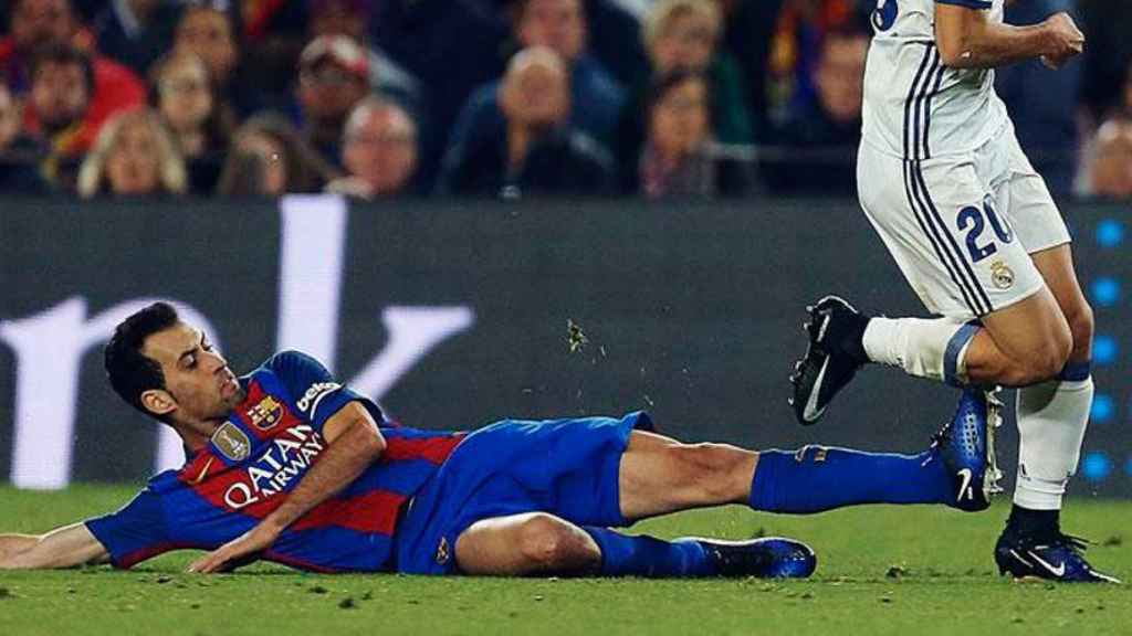 Una acción de Sergio Busquets en un partido entre el Madrid y el Barça disputado en el Bernabéu / EFE