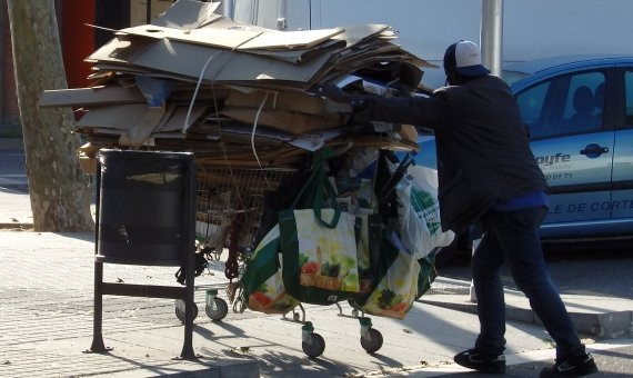 Un hombre empujando un carrito de la compra lleno de residuos / D.B.