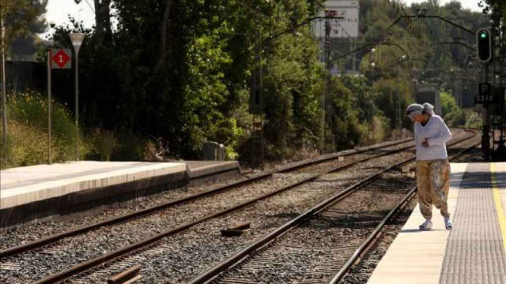 Una mujer observa las vías del tren / EFE