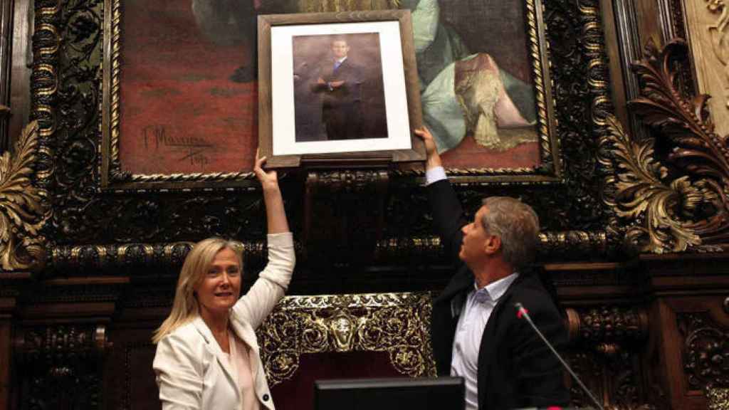 Ángeles Esteller y Alberto Fernández, del PP cuelgan la foto del Rey en el salón de plenos del Ayuntamiento en 2015 / EFE