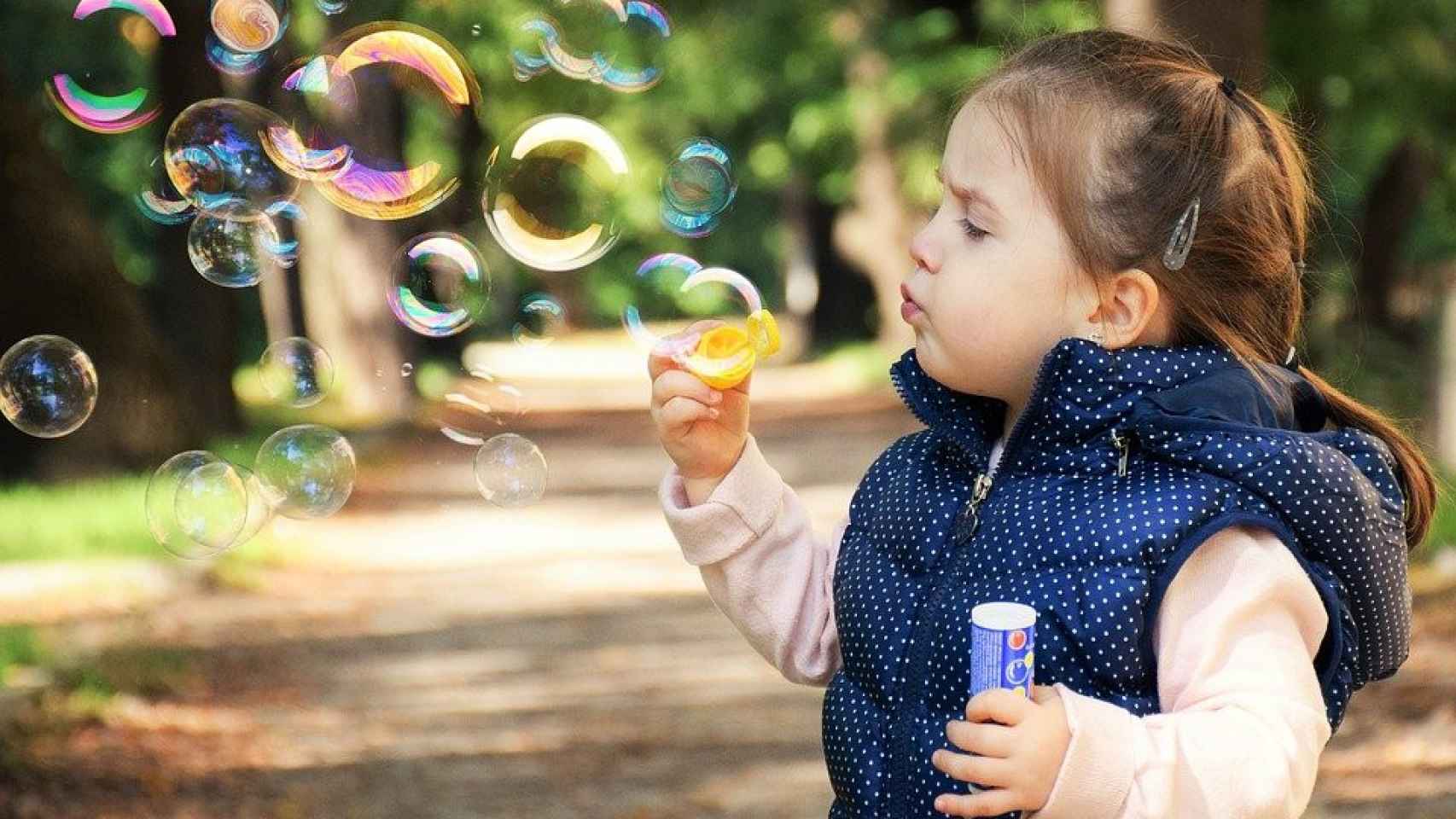 Una niña jugando con pompas de jabón / Daniela Dimitrova