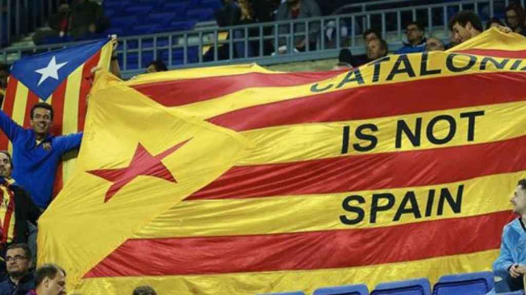 Aficionados del Barça exhiben una gran estelada en un Camp Nou con muchos asientos libres / EFE