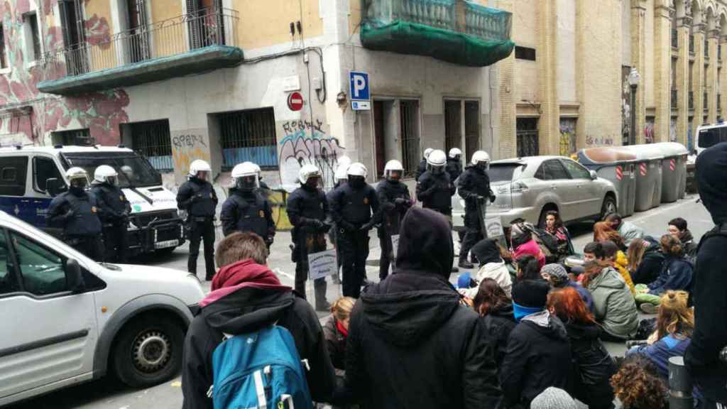 Agentes de la USP, que han perdido unos 100 integrantes, con cascos y escudos durante una actuación en el Raval por un edificio municipal 'okupado' / Twitter