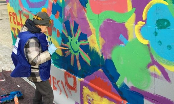 Un niño ingresado en el Hospital de Vall d'Hebron haciendo su aportación al mural colectivo / X.A.