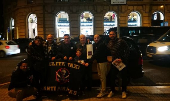 El equipo de Elite Taxi posando con la familia y la bandera