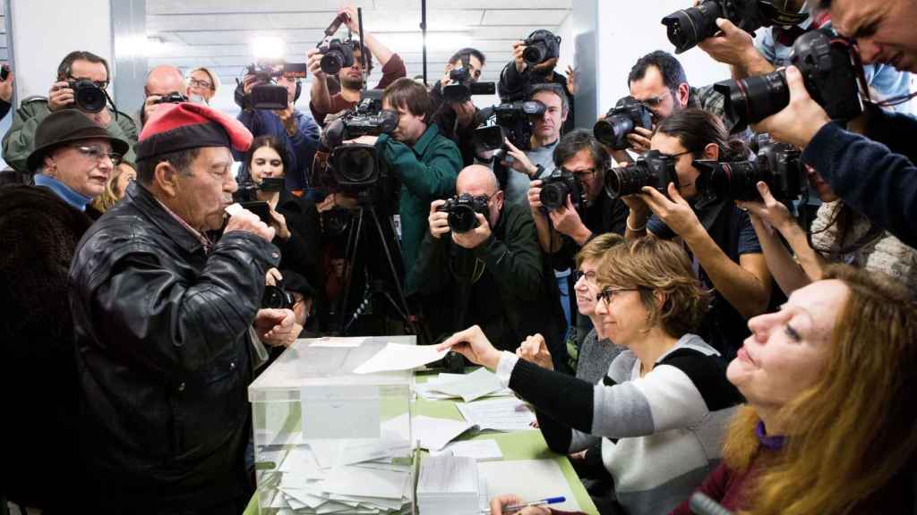 Un ciudadano con la típica barretina catalana, ejerce su derecho al voto en el colegio electoral Ausiàs March del barrio de Les Corts / EFE/Alberto Estévez