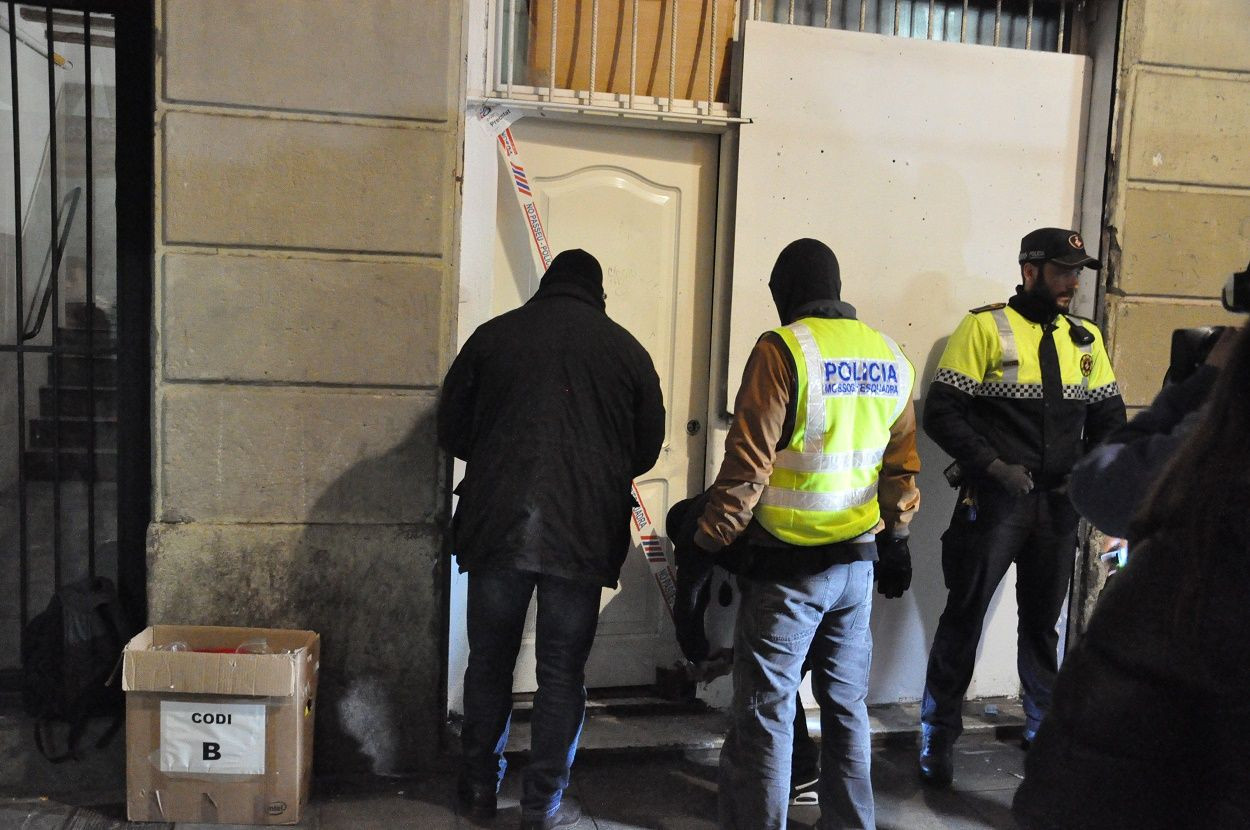 Momento  en que los Mossos d'Esquadra proceden a precintar la puerta de la finca / MIKI