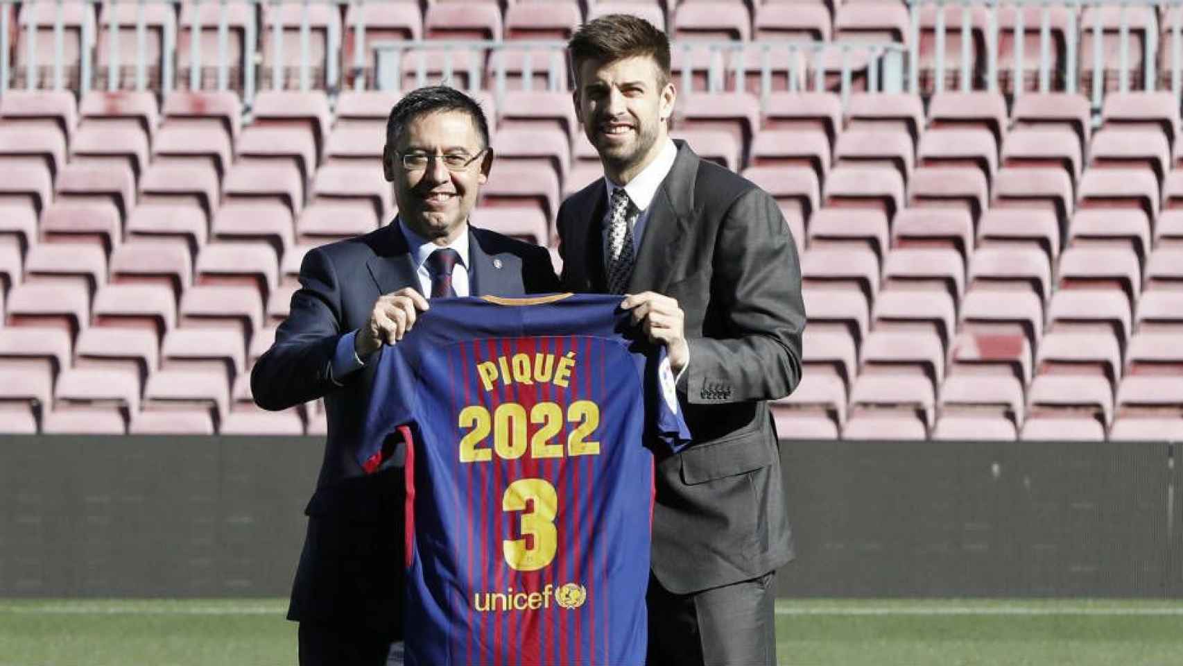 Gerard Piqué y Josep Maria Bartomeu, en el césped del Camp tras la firma de la renovación del jugador / EFE