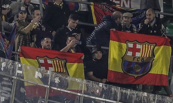 Dos seguidores del Barça despliegan sus banderas españolas en el campo del Betis