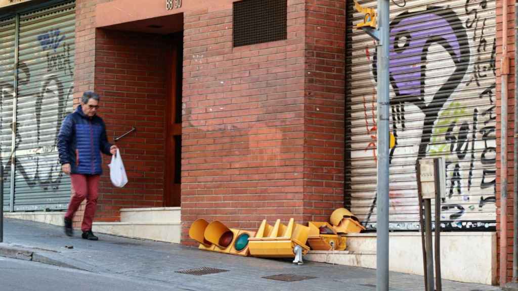 Semáforo tirado en la acera después de ser arrancado por el espejo retrovisor de un autobús, en el número 88 de la calle Mare de deu del coll / ÁLVARO