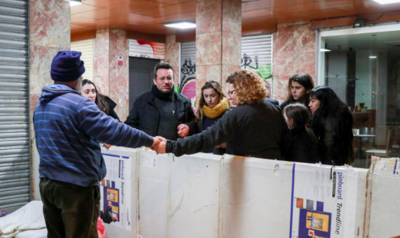 Los voluntarios rezan con el párroco en un portal / A.V.