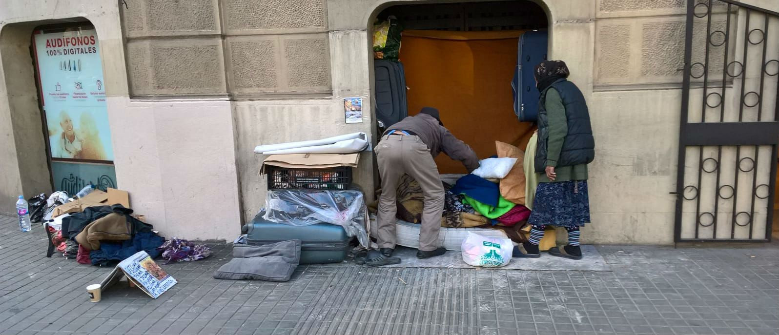 Dos personas mayores preparan su casa en la plaza de Urquinaona de Barcelona / METRÓPOLI ABIERTA