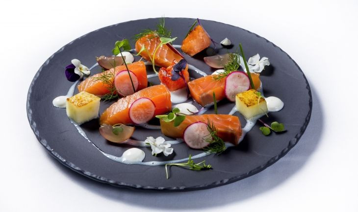 ensalada de salmón fresco marinado en casa con flores de coliflor tostadas