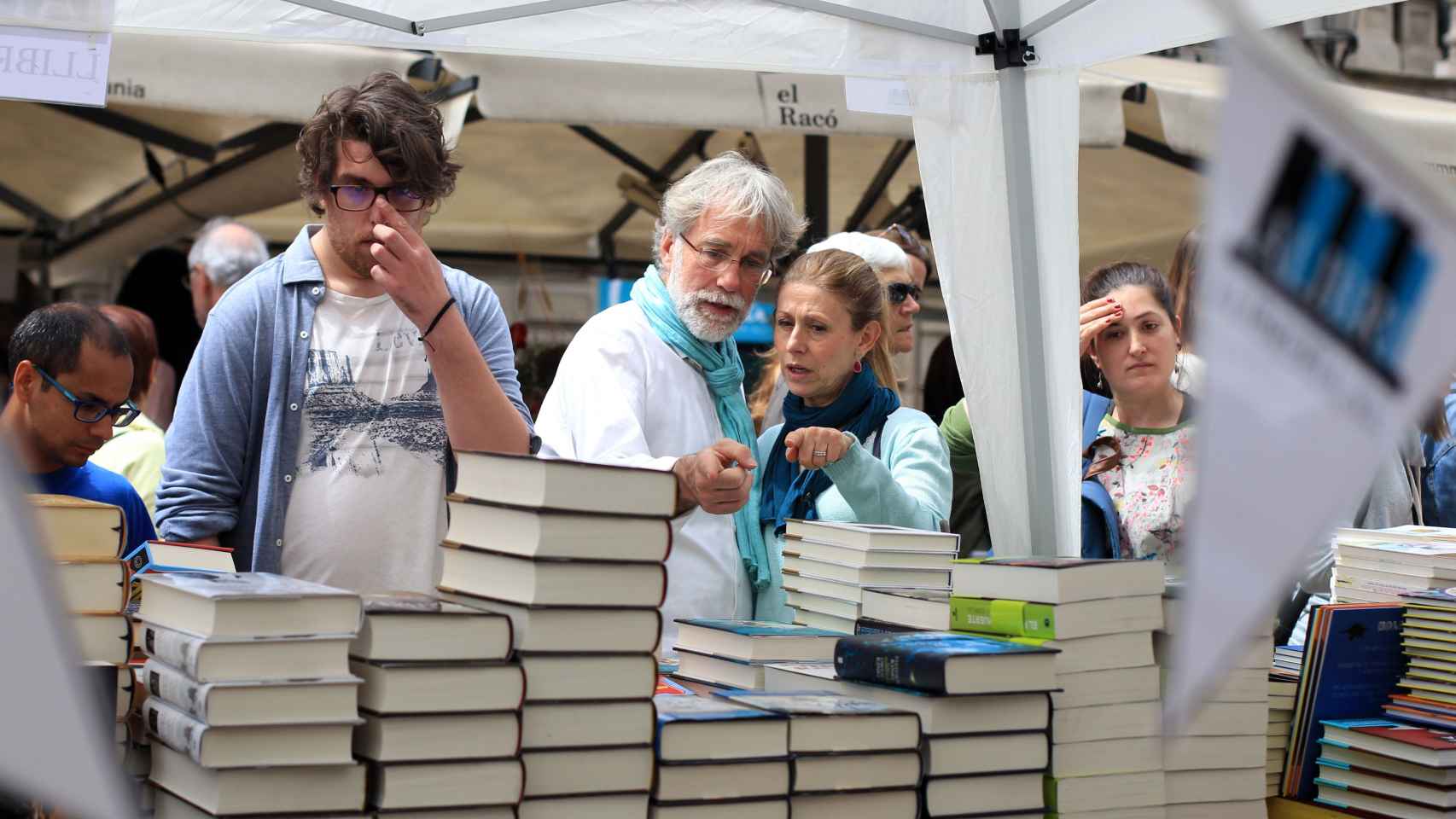 Una pareja señalando un libro durante la Diada de Sant Jordi en Barcelona | HUGO FERNÁNDEZ