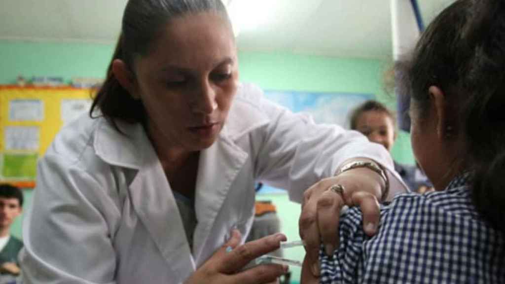 Una enfermera vacuna a una niña