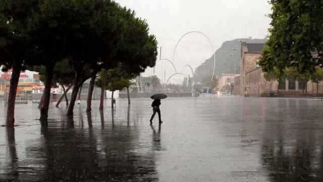 Un hombre se resguarda de la lluvia en Barcelona bajo un paraguas