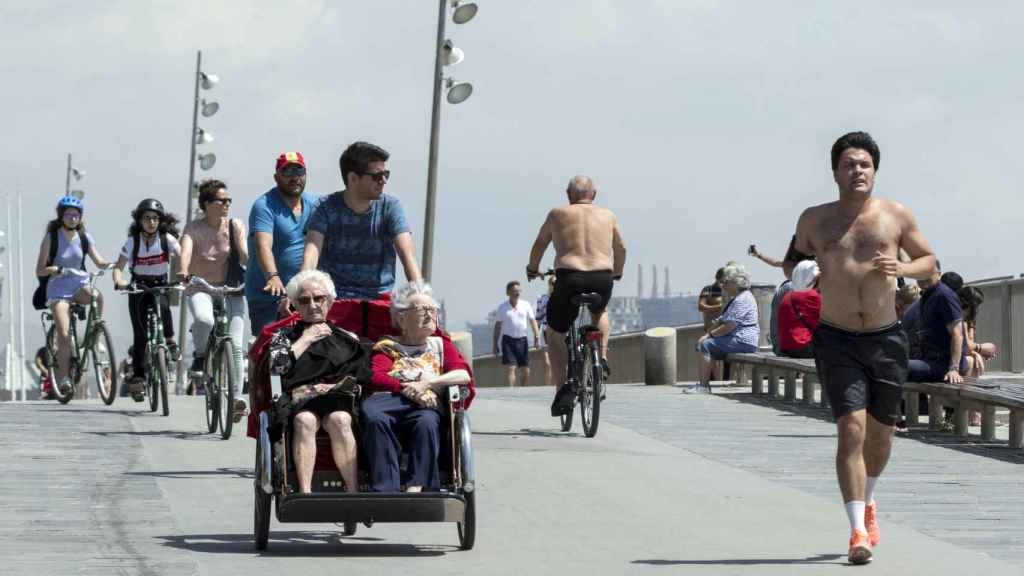 Dos ancianas recorren en bici-taxi la playa de Barcelona / HUGO FERNÁNDEZ