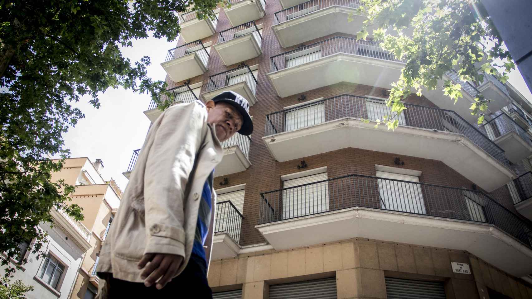 Un hombre pasa junto al edificio fantasma del Raval, en la ronda de Sant Pau / HUGO FERNÁNDEZ