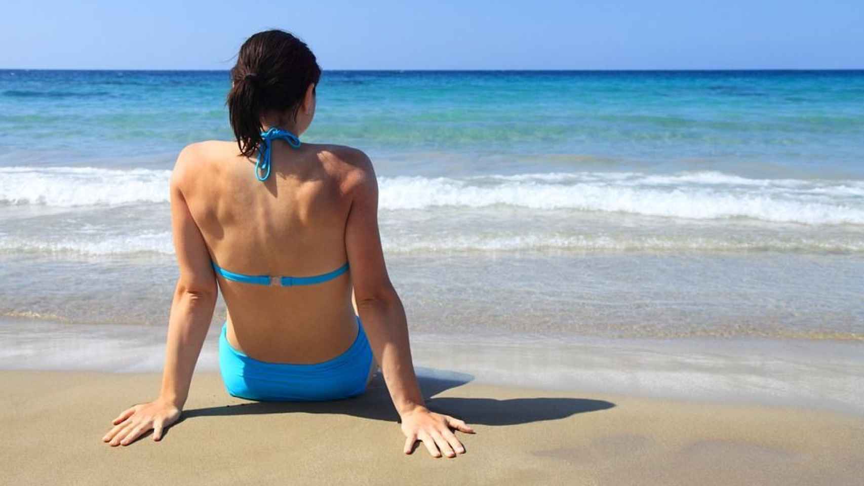 Una mujer toma el sol en la playa