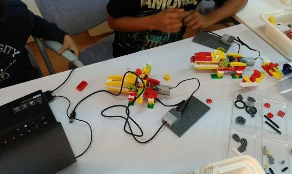 Dos niños trabajan con ordenadores y piezas de lego en Peques&Robots / PEQUES&ROBOTS 