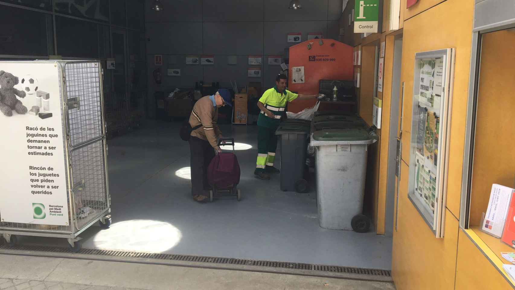 Manuel Sánchez atiende a un ciudadano en el punto verde de la Sagrada Família, uno de los equipamientos como los que sufren robos y agresiones / JORDI SUBIRANA