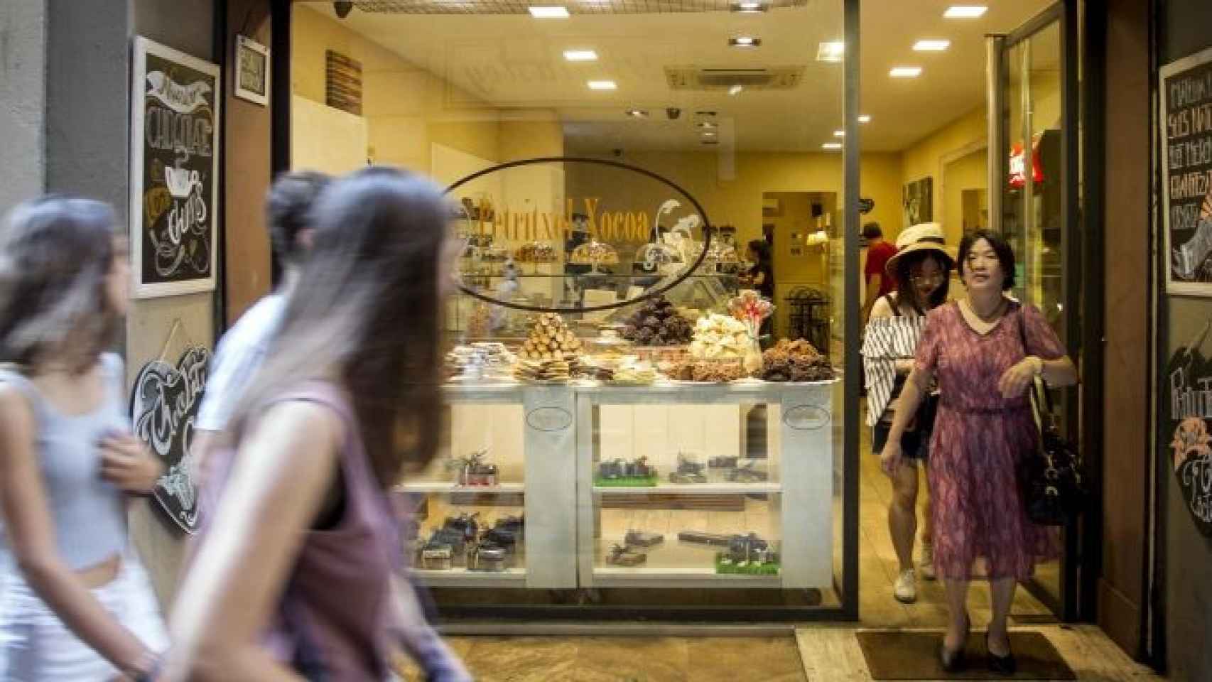 Turistas paseando por delante de una chocolatería de la calle de Petritxol