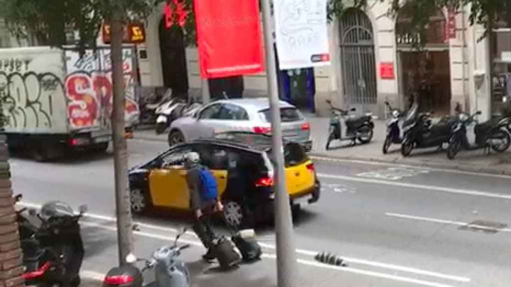 Turista caminando por el carril bici con las maletas