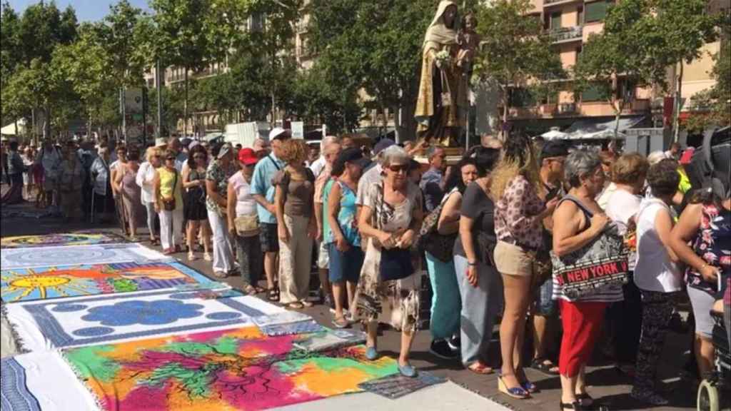 Algunos asistentes a la procesión optan por pasar por encima de las prendas que venden los manteros.