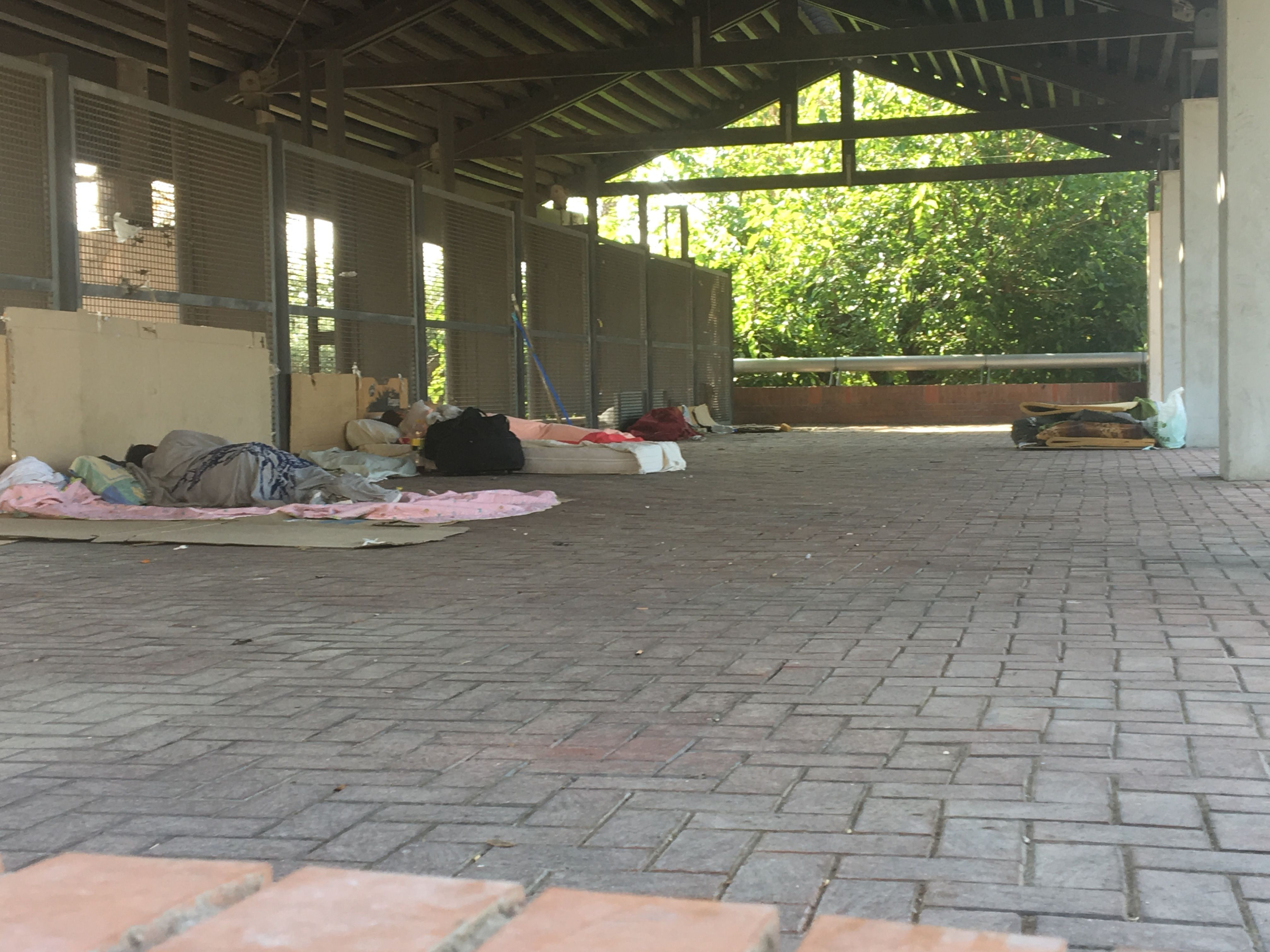 Varias personas sintecho durmiendo en la pérgola de la plaza de los Campions / JORDI SUBIRANA