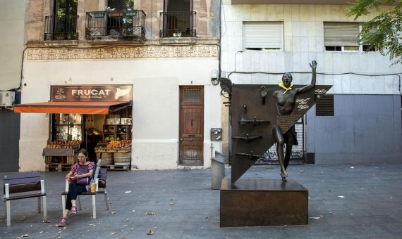 Una mujer descansa junto a 'La Colometa' en la plaza del Diamant / Hugo Fernández