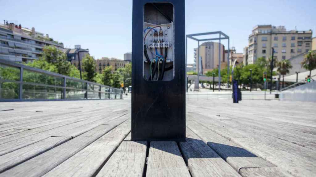 Cables al descubierto en una farola en la plaza Lesseps / HUGO FERNÁNDEZ