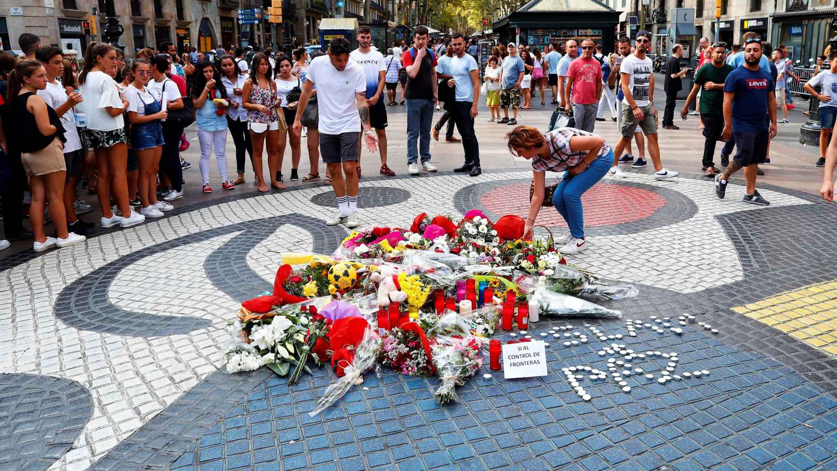 Flores depositadas por ciudadanos anónimos en el mosaico de Miró / EFE