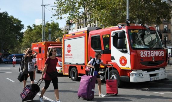 Turistas inadvertidos abandonan la plaza Catalunya con sus enseres / MIKI