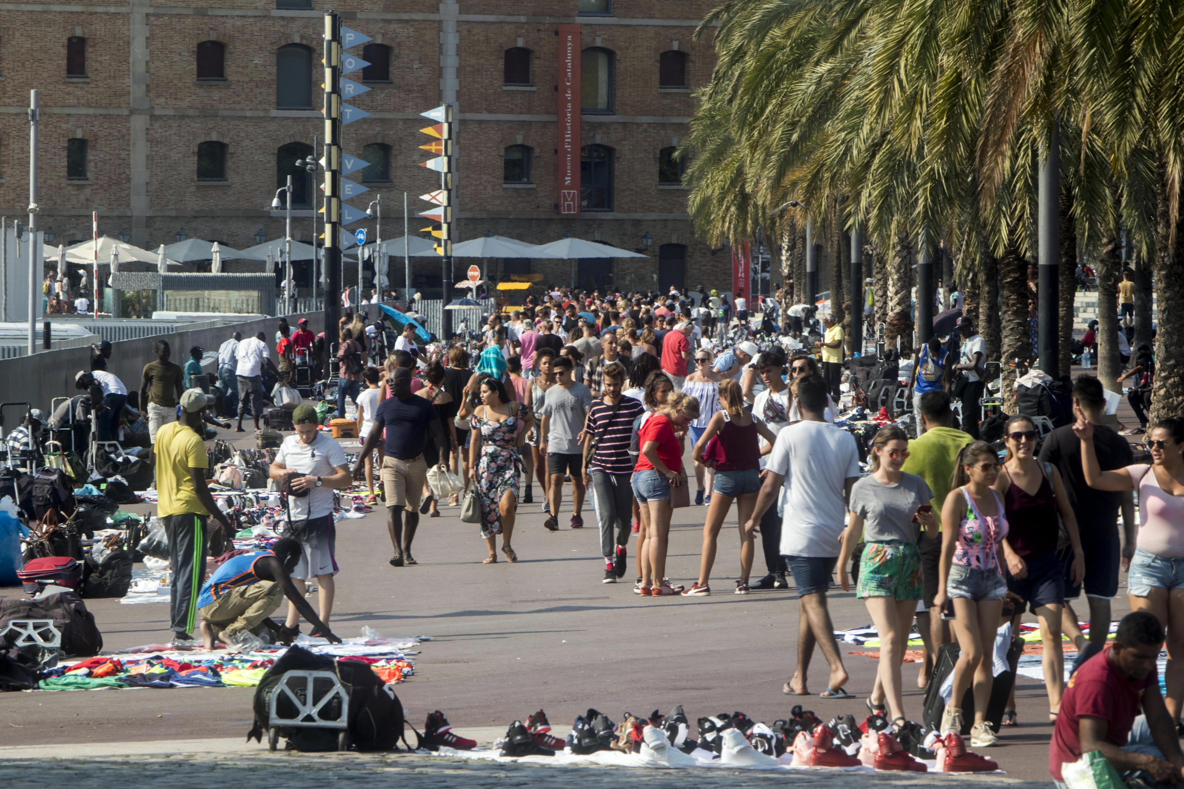 Turistas y manteros en el paseo Joan de Borbó | HUGO FERNÁNDEZ