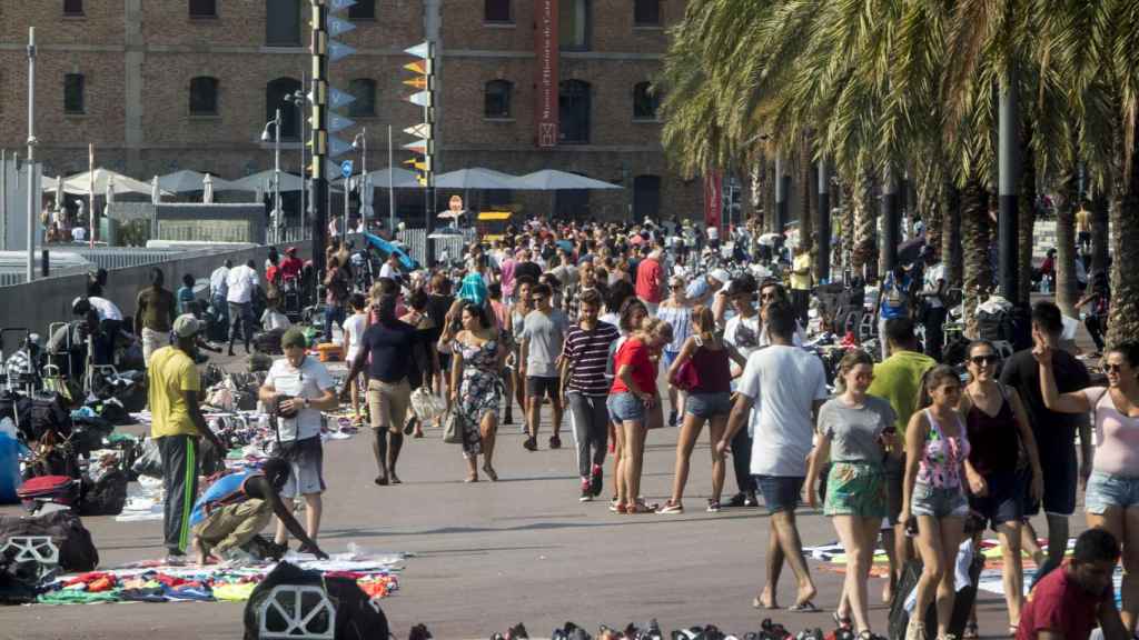 Turistas y manteros en el paseo Joan de Borbó | HUGO FERNÁNDEZ