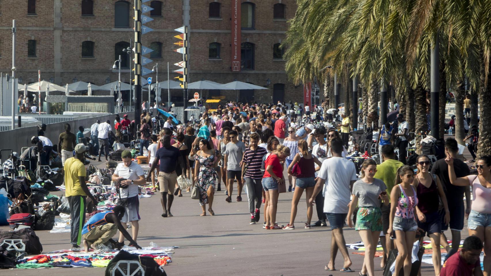 Turistas y manteros en el paseo Joan de Borbó, en la Barceloneta