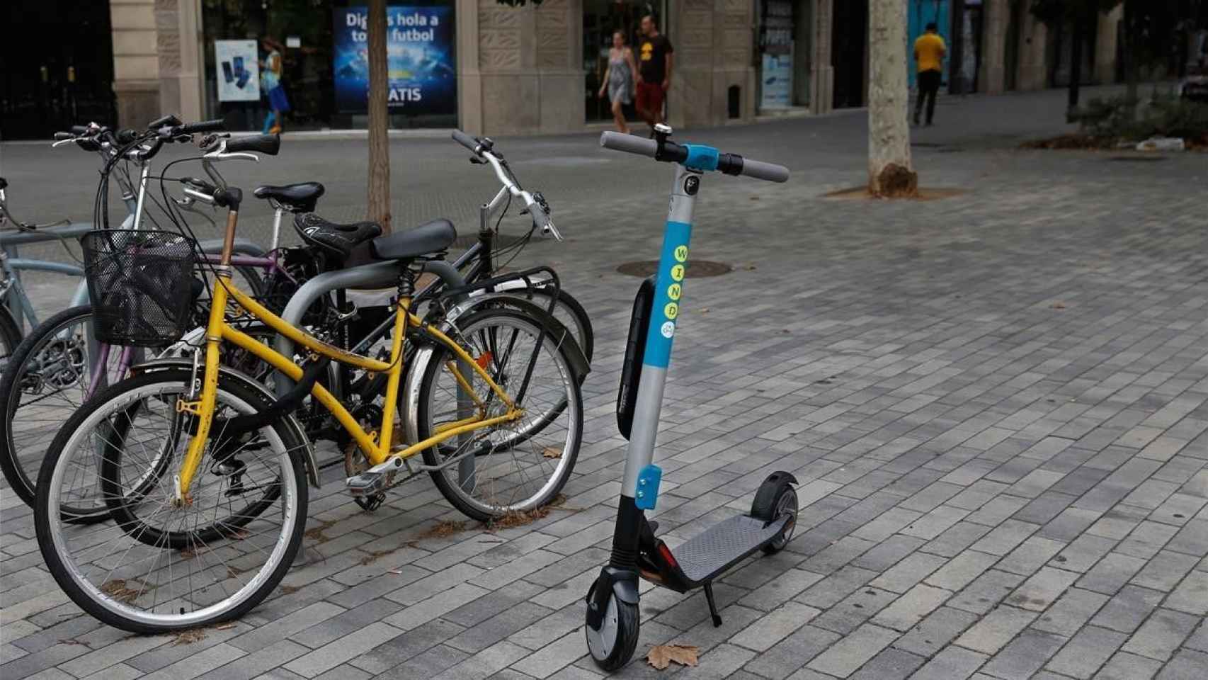 Un patinete eléctrico compartido de Wind, esta tarde en la acera de Consell de Cent. / ÁLVARO MONGE (El Periódico)