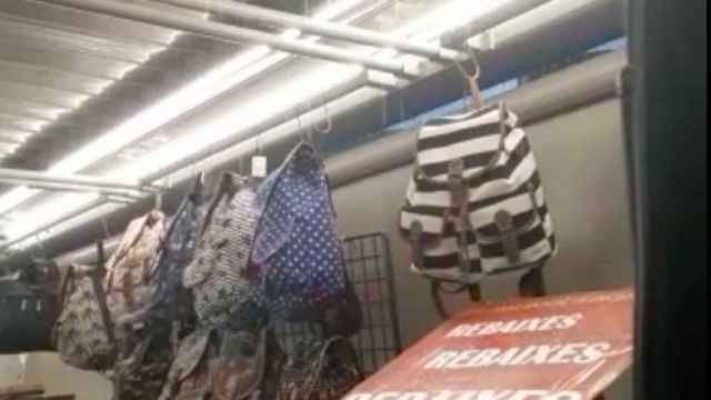 Un comerciante, en su parada de ropa, con la lluvía cayendo a chorros