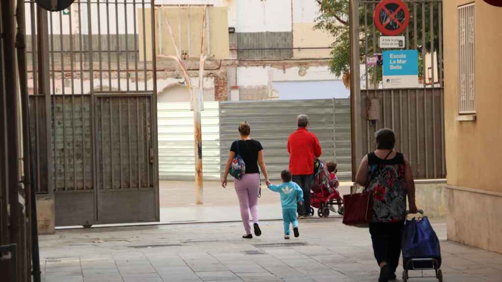 Alumnos entran junto a sus madres en la escuela de la Mar Bella en obras, esta semana / JORDI ROMERO