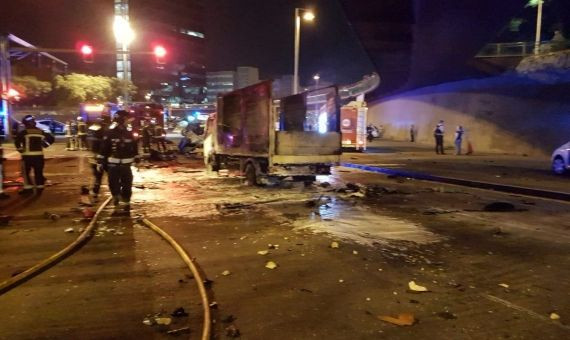 Bomberos junto al camión incendiado en el accidente de la ronda del mig / @GUBMOSQUEADO