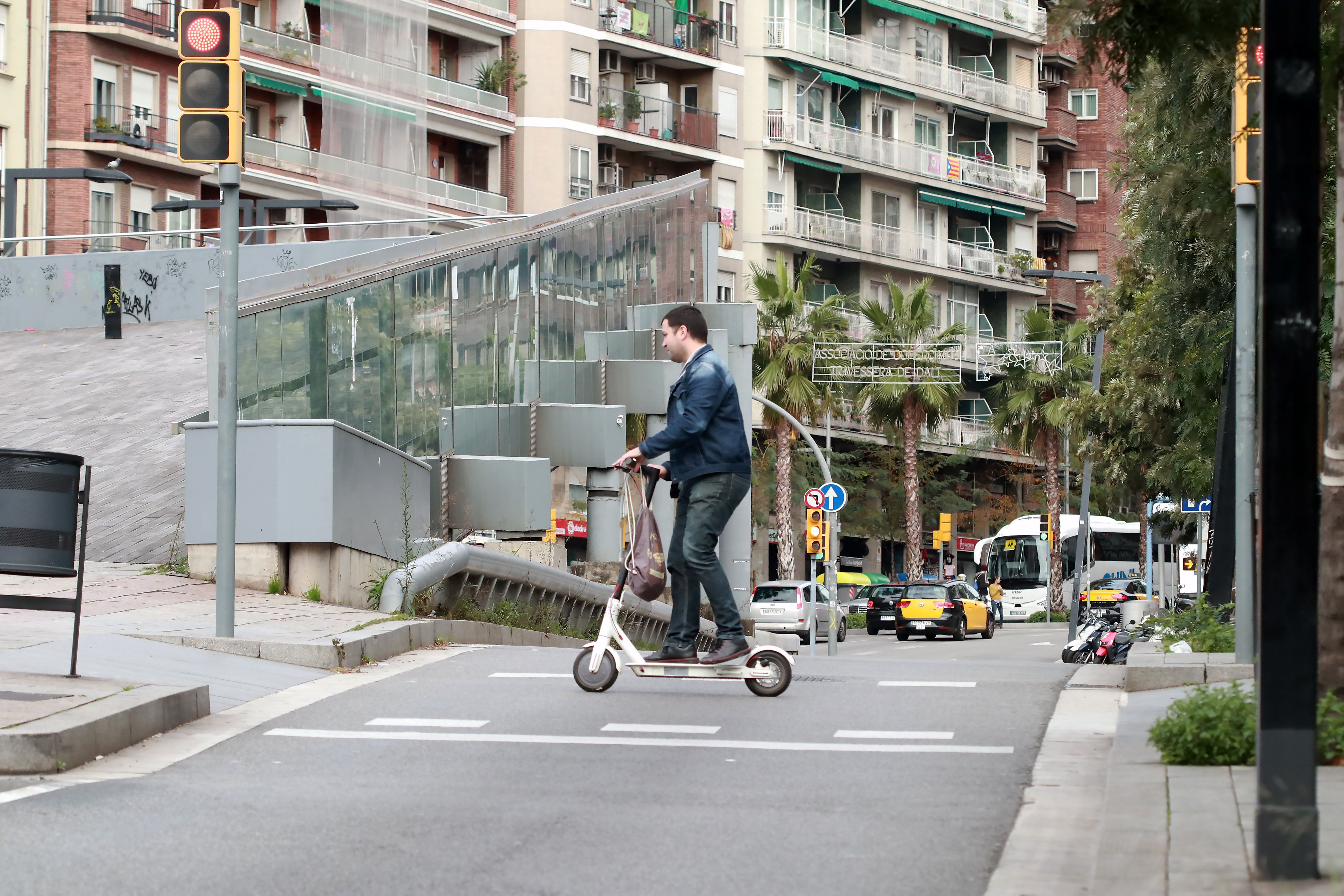 Un hombre circula con patinete eléctrico en la plaza Lesseps, de Barcelona / H.F.