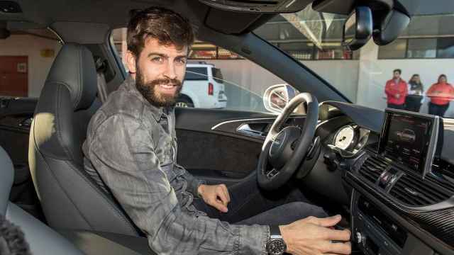 Gerard Piqué posa sonriente en su coche