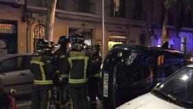 Varios bomberos contemplan el coche que ha provocado el inusual accidente / MIKI