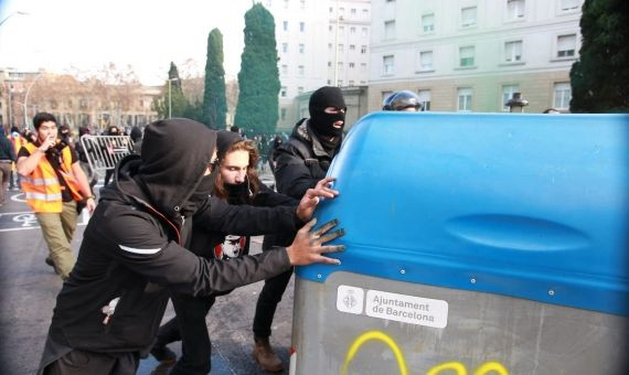 Radicales empujan contenedores para formar barricadas / HUGO FERNÁNDEZ